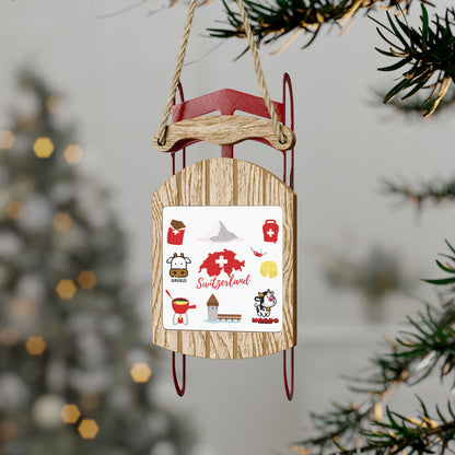 Wooden sled ornament with Swiss travel and culture icons including the Matterhorn, fondue pot, and Swiss cow