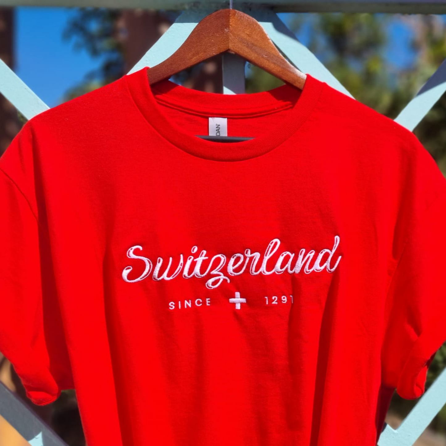 <img src="switzerland-embroidered-red-shirt.jpg" alt="Red shirt with 'Switzerland Since 1291' embroidery for travel and nature fans">